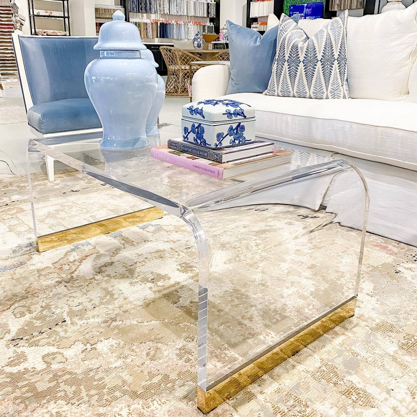 A styled vignette — acrylic and gold side table with curated objects.